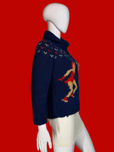 Load image into Gallery viewer, A navy blue knit zip-up cardigan sweater with a hood, featuring two large red and beige dancer motifs on the front, displayed on a white mannequin.
