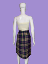 Load image into Gallery viewer, A purple, green, and cream plaid skirt displayed on a white mannequin. 
