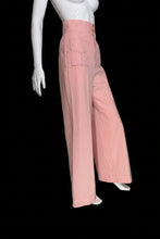 Load image into Gallery viewer, A pair of high-waisted, wide-leg pink pants displayed on a white mannequin. The pants feature a buttoned waistband with gold-tone buttons.
