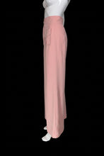 Load image into Gallery viewer, A pair of high-waisted, wide-leg pink pants displayed on a white mannequin. The pants feature a buttoned waistband with gold-tone buttons and two large patch pockets in the front.
