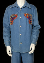 Load image into Gallery viewer, A close up of a blue denim two-piece set consisting of a long-sleeve button-front shirt and matching pants, displayed on a white mannequin. The shirt features colorful embroidered  patterns on the chest in red, orange, and yellow.
