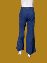Load image into Gallery viewer, A pair of wide-leg blue denim jeans with checkered stitching displayed on a white mannequin shown from the back.
