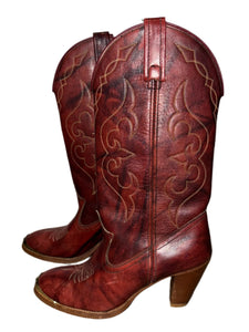 Brown leather boot with intricate designs on a white and gray background
