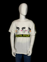 Load image into Gallery viewer, A white graphic t-shirt displayed on a white mannequin torso. The shirt features a cartoon graphic of three characters and 'OCEAN PACIFIC' banner across the chest.
