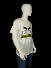 Load image into Gallery viewer, A white graphic t-shirt with a cartoon print of two men and the text 'OCEAN PACIFIC'.
