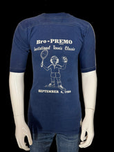Load image into Gallery viewer, A vintage blue short-sleeve t-shirt displayed on a white mannequin, showing the graphic which reads 'Bro-PREMO Invitational Tennis Classic SEPTEMBER 6, 1980' in white text and illustration.
