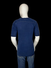Load image into Gallery viewer, A mannequin wearing a dark blue short-sleeve t-shirt and blue jeans, shown from the back.
