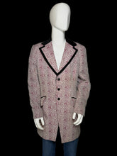 Load image into Gallery viewer, A men's blazer displayed on a white mannequin torso, featuring a pink and white patterned fabric with black piping along the lapels and front opening.
