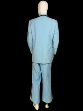 Load image into Gallery viewer, A light blue suit displayed on a white mannequin. The suit features dark blue contrast piping.
