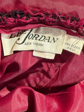Load image into Gallery viewer, Close-up of a vintage red or magenta satin garment interior showing a cream-colored 'Lee Jordan New York' brand label and a 'Dry Clean Only' tag.
