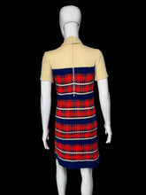 Load image into Gallery viewer, A short-sleeve mock-neck knit dress displayed on a white mannequin. The dress features a solid pale yellow upper section and a red, navy blue, and cream plaid patterned lower section.
