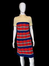 Load image into Gallery viewer, A short-sleeve mock-neck knit dress displayed on a white mannequin. The dress features a solid pale yellow upper section and a red, navy blue, and cream plaid patterned lower section.
