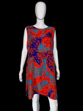 Load image into Gallery viewer, A sleeveless A-line dress with a vibrant red, orange, and blue paisley pattern, displayed on a white mannequin.
