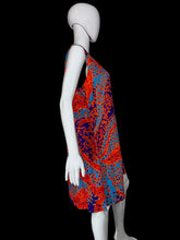 Load image into Gallery viewer, A sleeveless A-line dress with a vibrant red, orange, and blue paisley pattern, displayed on a white mannequin.
