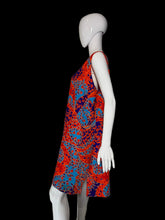 Load image into Gallery viewer, A sleeveless A-line dress with a vibrant red, orange, and blue paisley pattern, displayed on a white mannequin.
