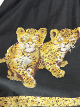 Load image into Gallery viewer, A close-up of a black garment featuring two golden-yellow leopard cubs with brown spots, and a matching patterned border along the bottom edge.
