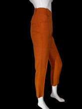Load image into Gallery viewer, Bright orange cropped trousers displayed on a white mannequin.
