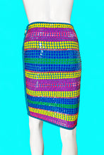 Load image into Gallery viewer, A colorful striped skirt displayed on a white mannequin from the back, featuring horizontal bands of yellow, blue, green, and magenta sequins with a teal border.
