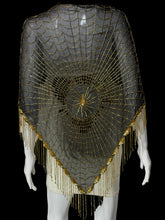 Load image into Gallery viewer, A black mesh triangular shawl or cape decorated with intricate gold beaded web-like patterns and a long fringe along the bottom, displayed on a white mannequin.
