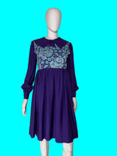 Load image into Gallery viewer, A long sleeve blue mini dress with a light blue and silver psychadelic print on the bodice and a dramatic collar shown on a white mannequin.
