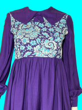 Load image into Gallery viewer, A long sleeve blue mini dress with a light blue and silver psychadelic print on the bodice and a dramatic collar shown on a white mannequin.
