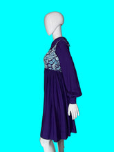 Load image into Gallery viewer, A long sleeve blue mini dress with a light blue and silver psychadelic print on the bodice and a dramatic collar shown on a white mannequin.
