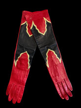 Load image into Gallery viewer, A pair of long red gloves with black panels and gold trim.
