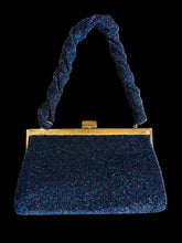 Load image into Gallery viewer, A dark blue beaded clutch handbag with a gold-tone metal frame and a knotted braided shoulder strap.
