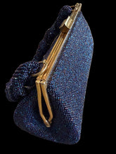 Load image into Gallery viewer, A dark blue beaded clutch handbag with a gold-tone metal frame and a knotted braided shoulder strap.
