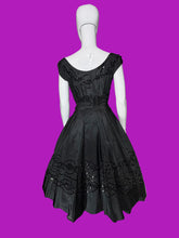 Load image into Gallery viewer, A black sleeveless fit-and-flare dress with cap sleeves, a scoop neckline, and ornate lace and bead trim details, displayed on a white mannequin.
