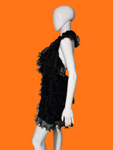 Load image into Gallery viewer, Black ruffled tulle dress shown on a white mannequin featuring a tiered ruffle skirt and a sheer ruffled collar shown from the side. 
