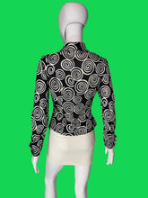 Load image into Gallery viewer, A long-sleeve button-up blouse with a black and white spiral swirl pattern, displayed on a white mannequin torso shown from the back.
