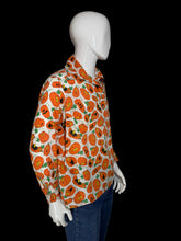 Load image into Gallery viewer, A long-sleeve button-up shirt with an all-over orange jack-o'-lantern pattern on a white background, displayed on a white mannequin torso.
