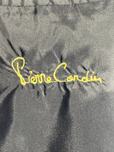 Load image into Gallery viewer, Close-up of a black textured fabric surface with yellow embroidered script reading 'Pierre Cardin'.
