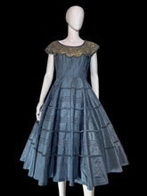 Load image into Gallery viewer, A blue tiered taffeta dress with a lace shoulder detail, displayed on a white mannequin.
