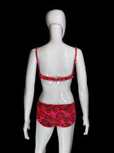 Load image into Gallery viewer, A two-piece bikini swimsuit with a vibrant pink, red, and green paisley pattern, displayed on a white mannequin shown from the back. 
