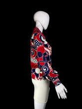 Load image into Gallery viewer, A long-sleeve button-up shirt with a bold abstract geometric pattern in red, navy blue, and white, displayed on a white mannequin torso.

