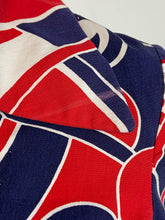 Load image into Gallery viewer, Close-up of a fabric product featuring an abstract geometric pattern in red, navy blue, and white.
