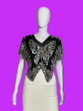 Load image into Gallery viewer, A black sleeveless dress displayed on a white mannequin, featuring a dramatic silver and clear beaded butterfly motif across the bodice.
