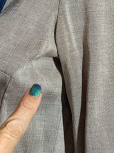 Load image into Gallery viewer, Close-up of a gray fabric with a hand pointing to a small imperfection.
