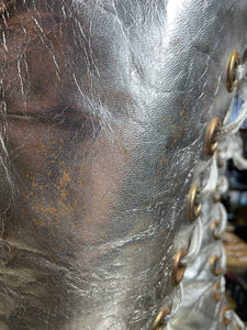 Close-up of a worn leather boot with visible scuff marks and stitching detail.