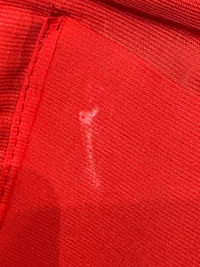 Close-up of red fabric  lining  with a visible white mark.
